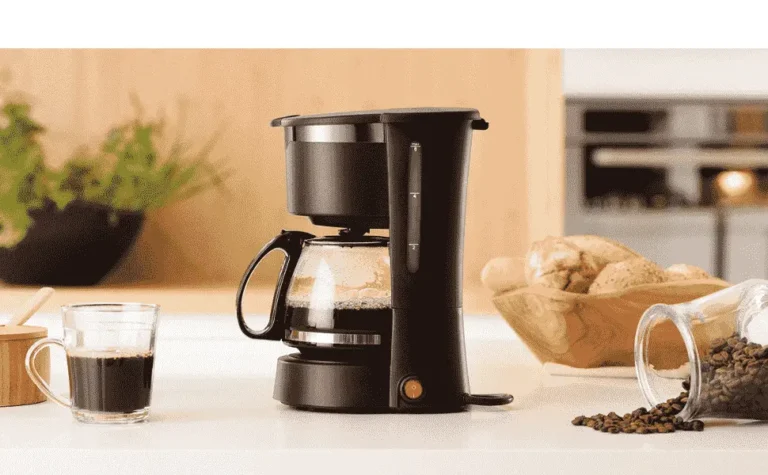Uma cafeteira elétrica moderna em aço inox passando café fresco em uma cozinha aconchegante, ilustrando a busca pela melhor cafeteira elétrica de 2026.